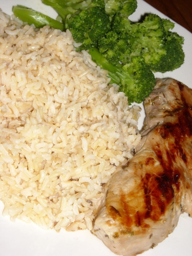 Baked Brown Rice on a plate with a pork chop. 