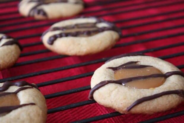 caramel macchiato thumbprint cookies drizzled with chocolate on a cookie tray