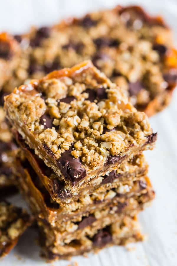 chewy caramel oatmeal bars stacked to show the oatmeal topping.