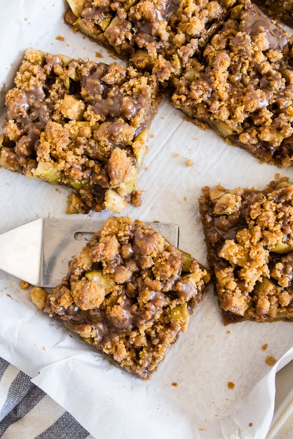 Cinnamon Apple Streusel Bars sliced on parchment paper.