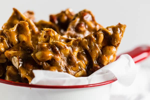 Homemade Maple Peanut Brittle in a storage tin.