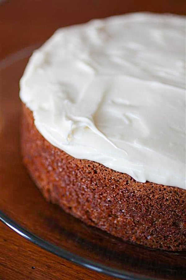 carrot cake with creamy cream cheese frosting on a glass plate