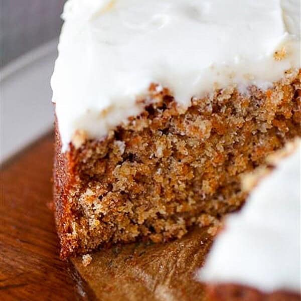 carrot cake with creamy cream cheese frosting cut with one slice missing