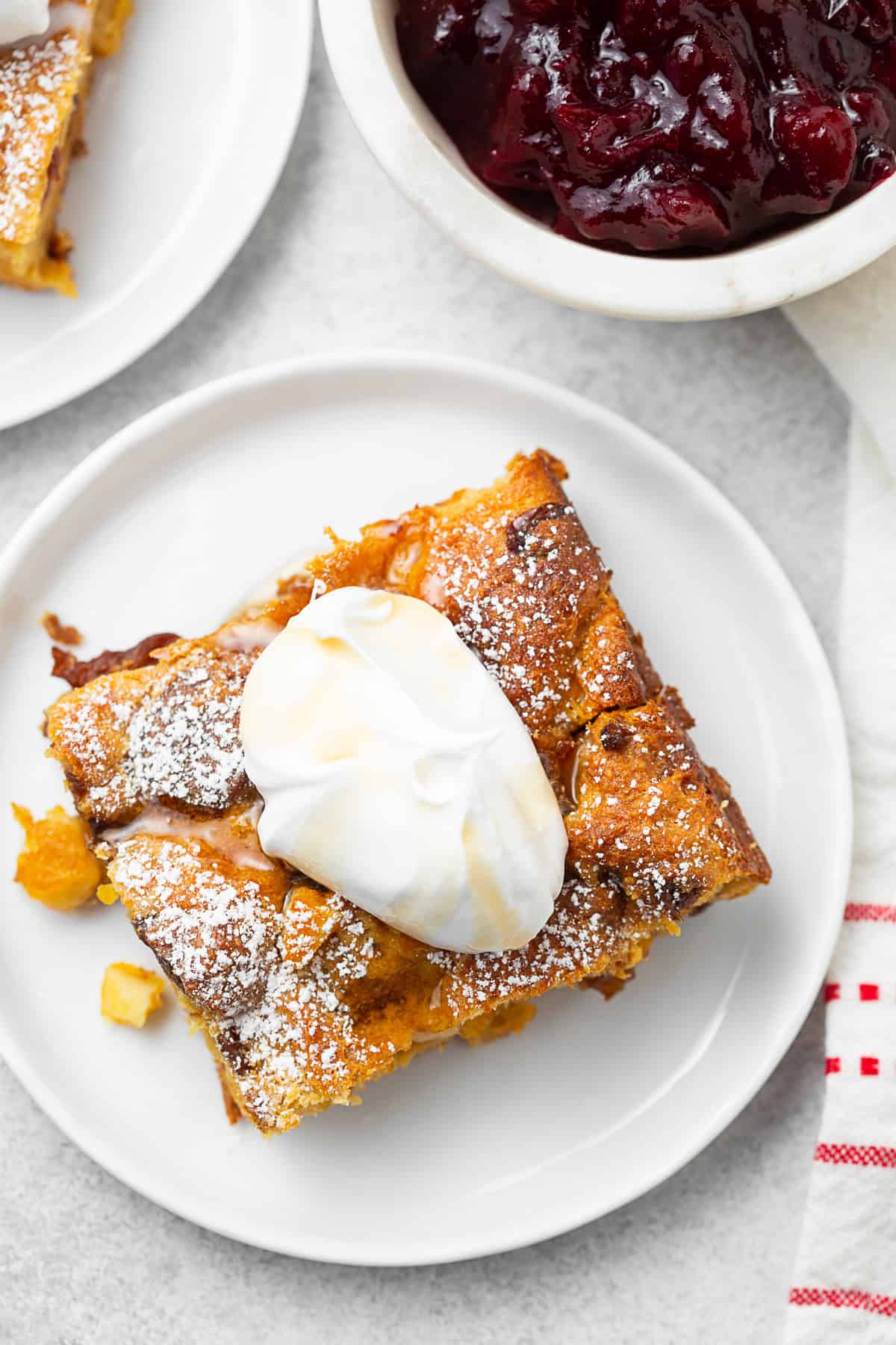 Panettone Bread Pudding on a white plate topped with greek yogurt. 