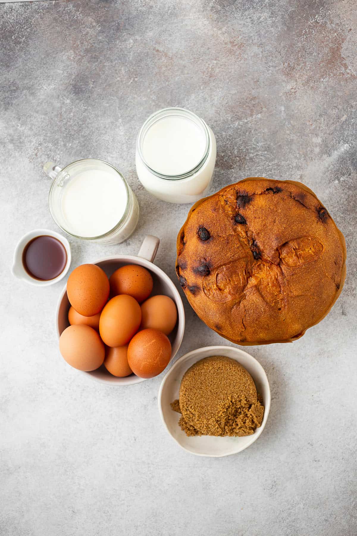 Bread, eggs, milk, and brown sugar on a table. 