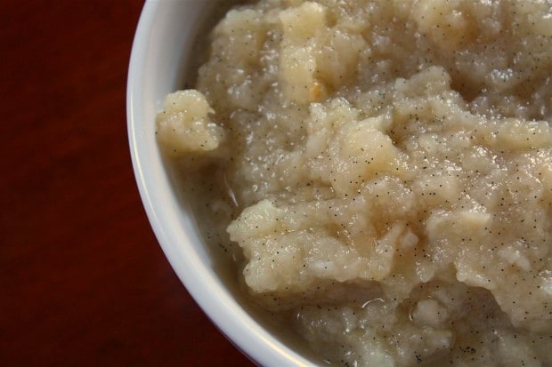 vanilla bean pear sauce sitting in a while bowl on a wooden table