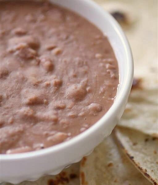 These Southern style pinto beans only take 4 ingredients and cost less than $5 to make! They are perfect eaten plain or rolled up in a soft flour tortilla.