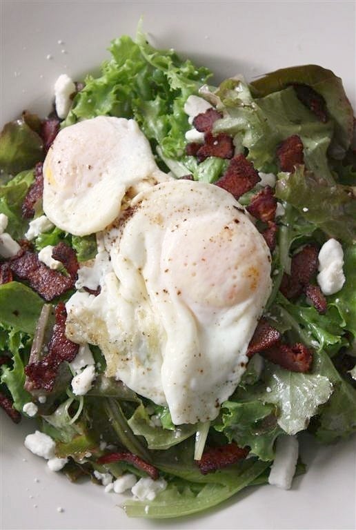 This mixed green salad with bacon, goat cheese, and fried egg is a lovely protein packed salad. It's great for lunch or dinner! Mixed Green Salad with Bacon, Goat Cheese and Fried Egg in a bowl.