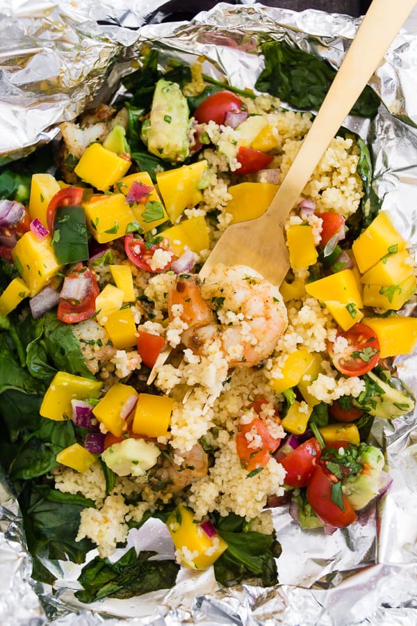 shrimp and couscous packets wrapped in foil with a fork