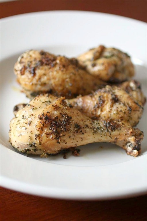 Roasted chicken legs on a white plate. 