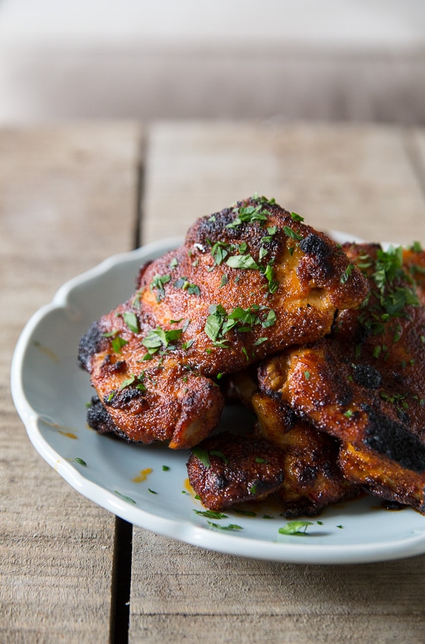 Crispy, browned chicken thighs on a light blue serving plate.