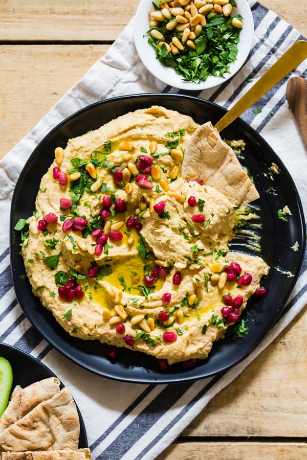 Tahini Free Hummus on a plate with pita bread.