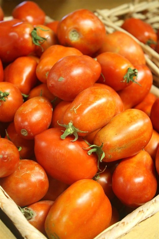 A box full of roma tomatoes. 