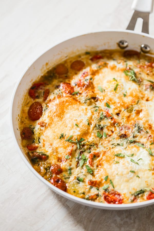 Bruschetta Baked Eggs in a skillet. 