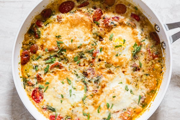 Bruschetta Baked Eggs served in a skillet. 