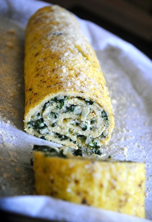 Spinach Artichoke Egg Roulade sliced on a sheet pan. 