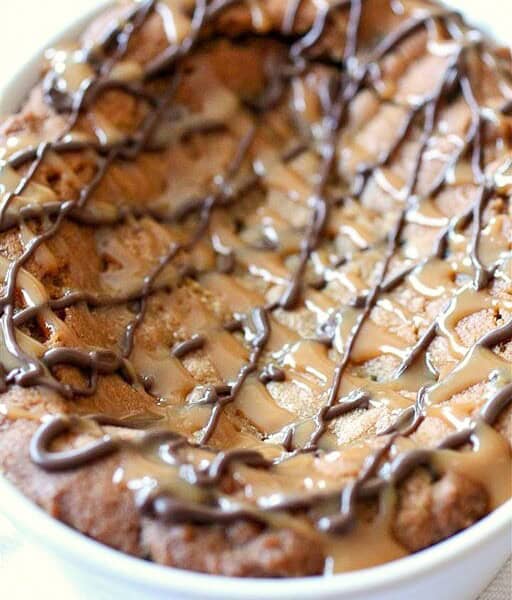 This super deep dish chocolate chip cookie is packed full of flavor and drizzled with melted chocolate and lots of salted caramel.