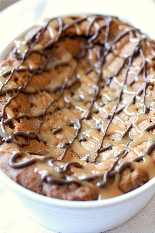 This super deep dish chocolate chip cookie is packed full of flavor and drizzled with melted chocolate and lots of salted caramel.