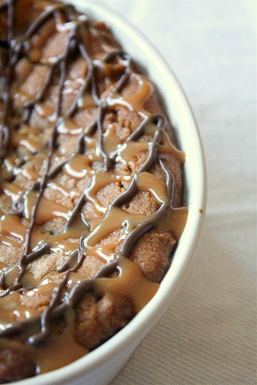 This super deep dish chocolate chip cookie is packed full of flavor and drizzled with melted chocolate and lots of salted caramel.