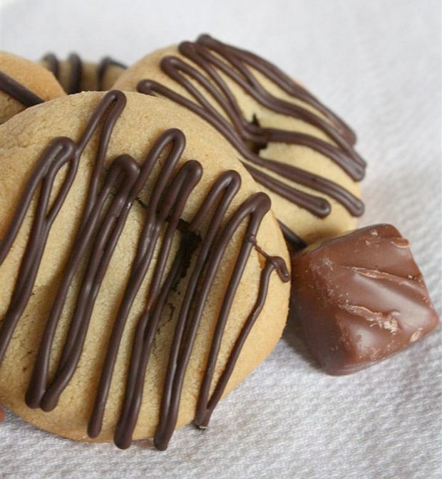 Peanut Butter Snickers Cookies by Nutmeg Nanny Sweet peanut butter Snicker cookies drizzled with chocolate and made with love. They are the perfect addition to your Christmas platter.