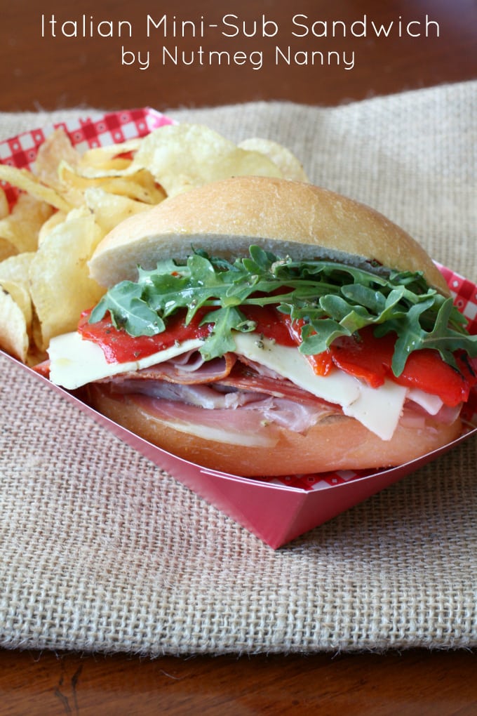 Italian Mini Sub Sandwiches with Homemade Sub Sauce by Nutmeg Nanny Italian sub sandwich drizzled with homemade sub sauce and potato chips on the side.