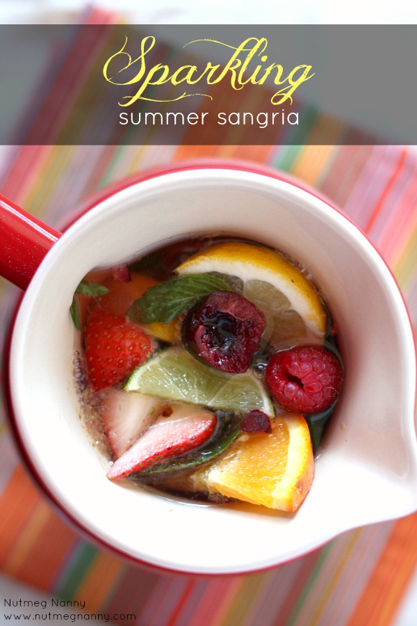 Sparkling Summer Sangria by Nutmeg Nanny Sparkling Summer Sangria in a red pitcher.