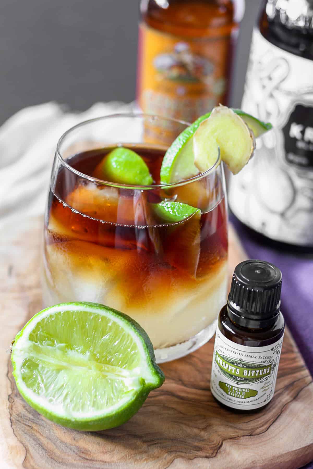 Dark and Stormy Cocktail served with bitters and a lime. 