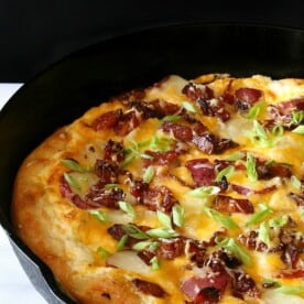 loaded baked potato pizza in a cast iron skillet