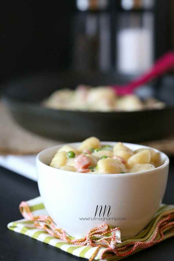 Skillet Cheesy Gnocchi with Peas and Ham in a skillet and bowl.