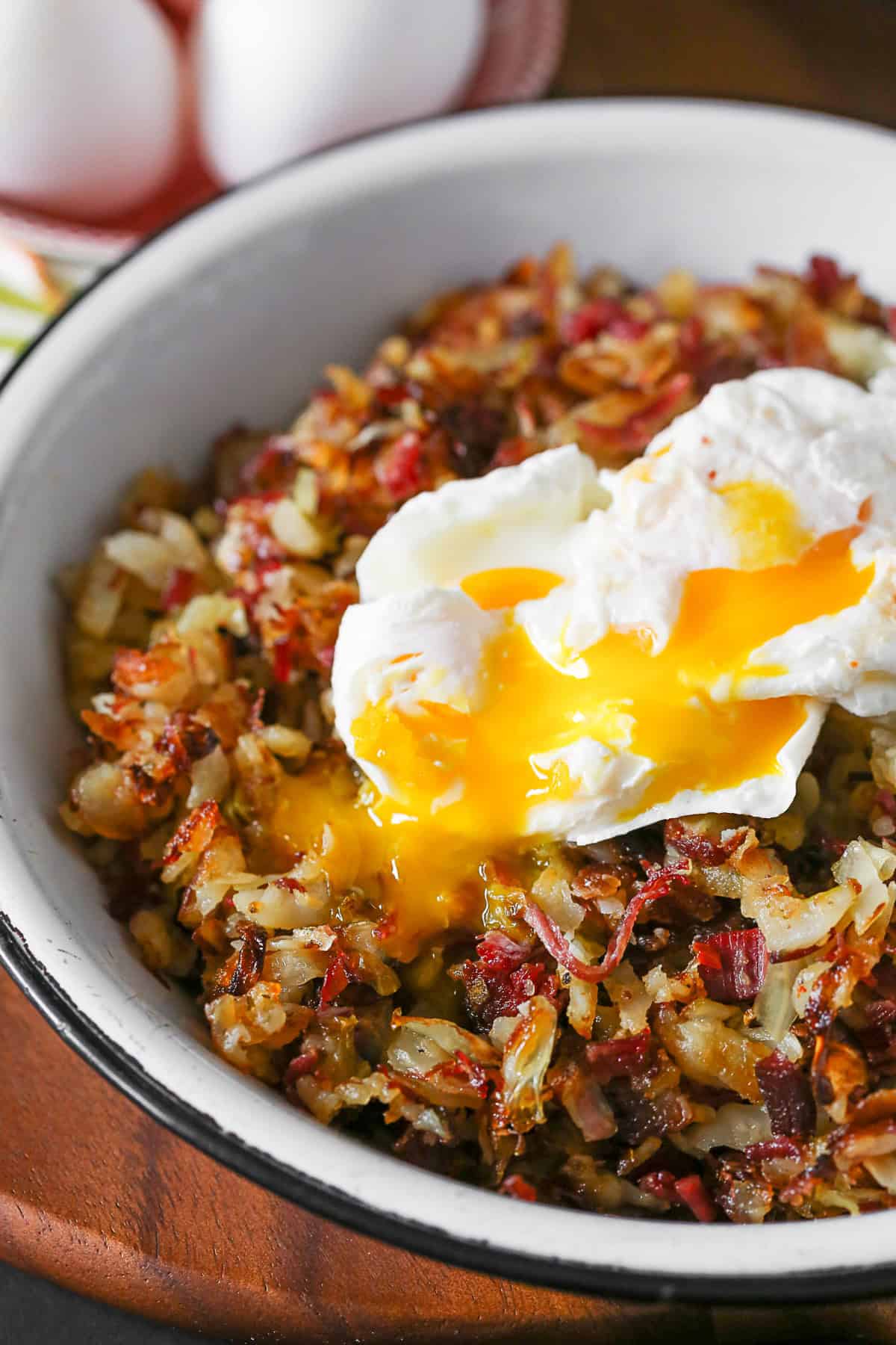Corned Beef Hash with a poached egg popped open so the yolk is running.