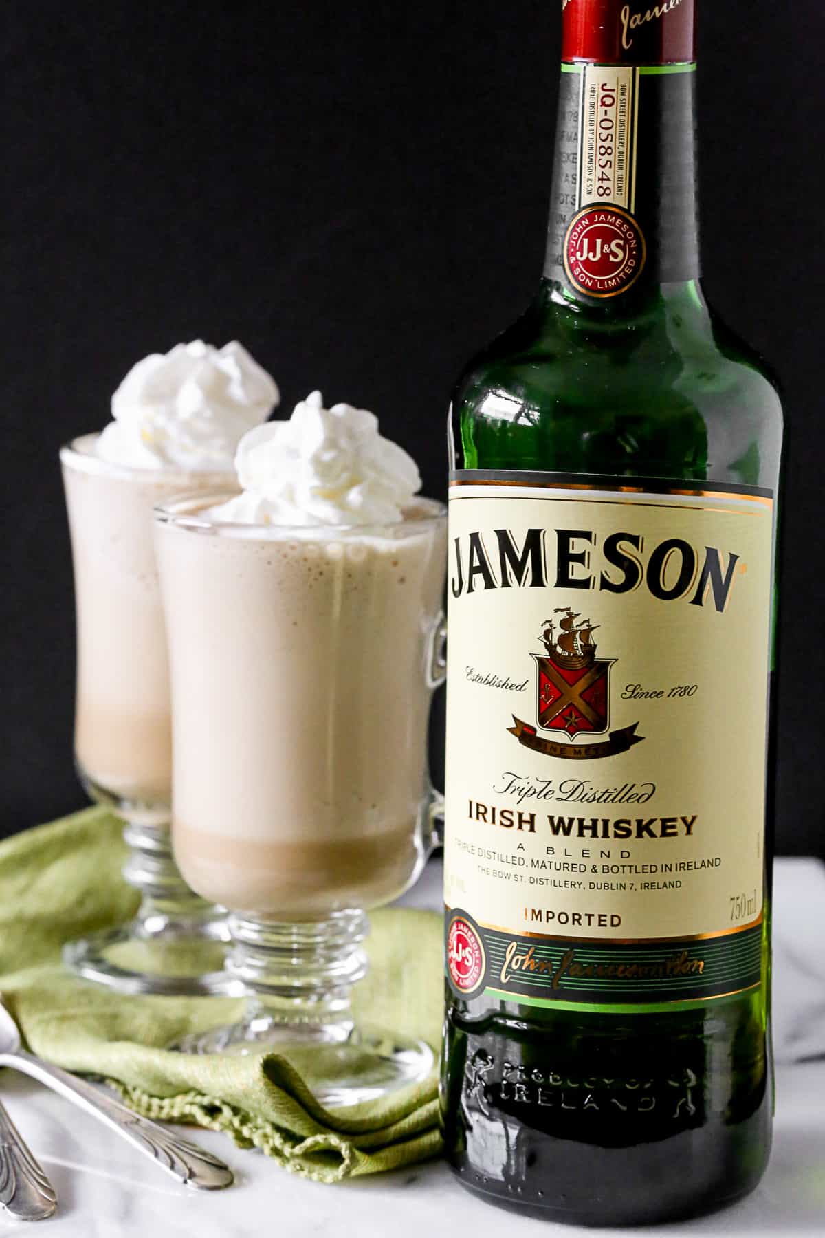 Irish Coffee Frappe by Nutmeg Nanny Irish Coffee Frappe on a table with a bottle of Irish whiskey.