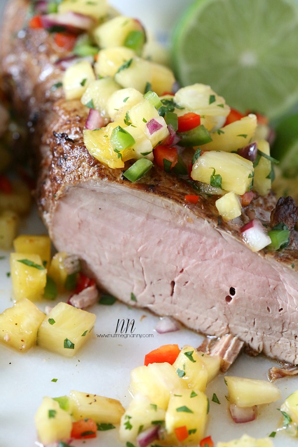Pork Tenderloin with Pineapple Salsa sliced on a platter. 