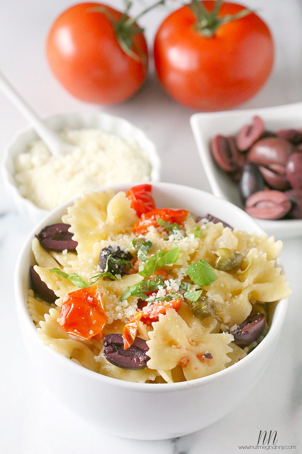 {20 Minute} Kalamata Olive, Tomato and Caper Pasta by Nutmeg Nanny Kalamata Olive, Tomato and Caper Pasta in a white bowl.