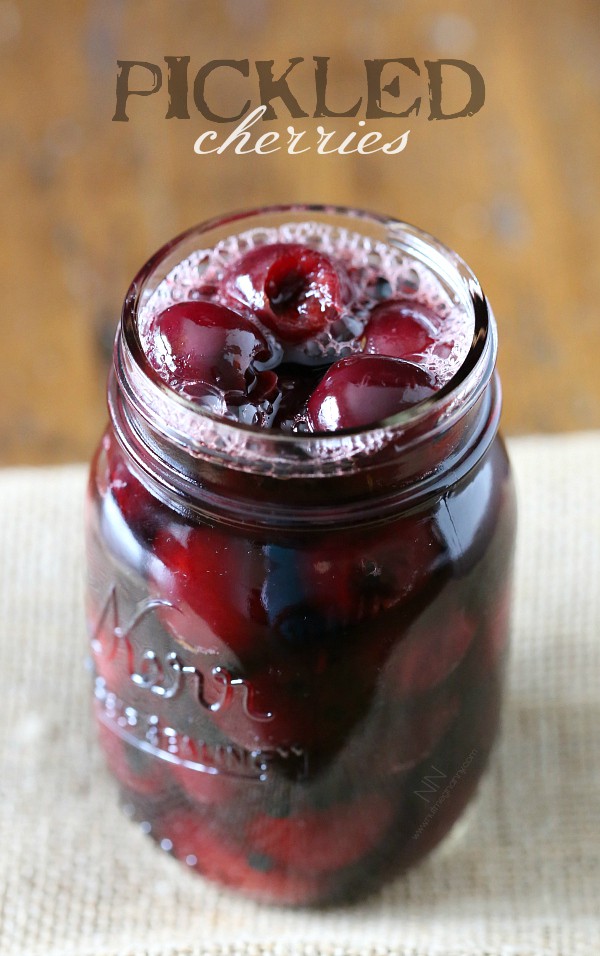 Pickled cherries in a glass quart jar.