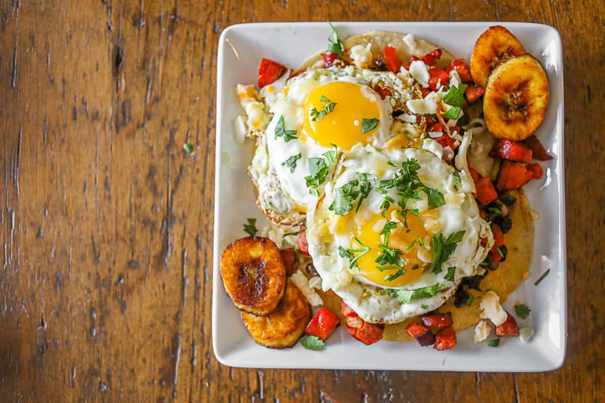 Huevos Motuleños on a small white plate. 