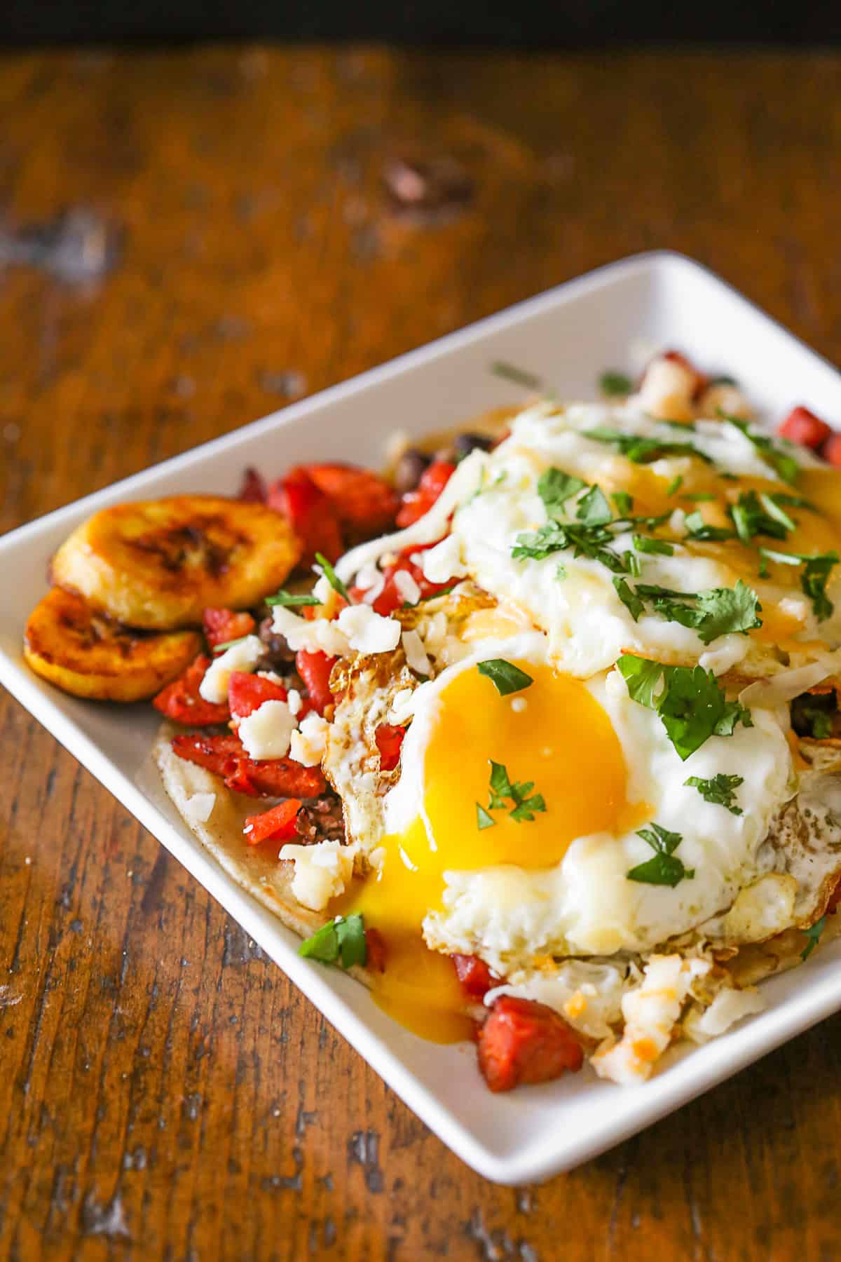Huevos Motuleños topped with a runny egg. 