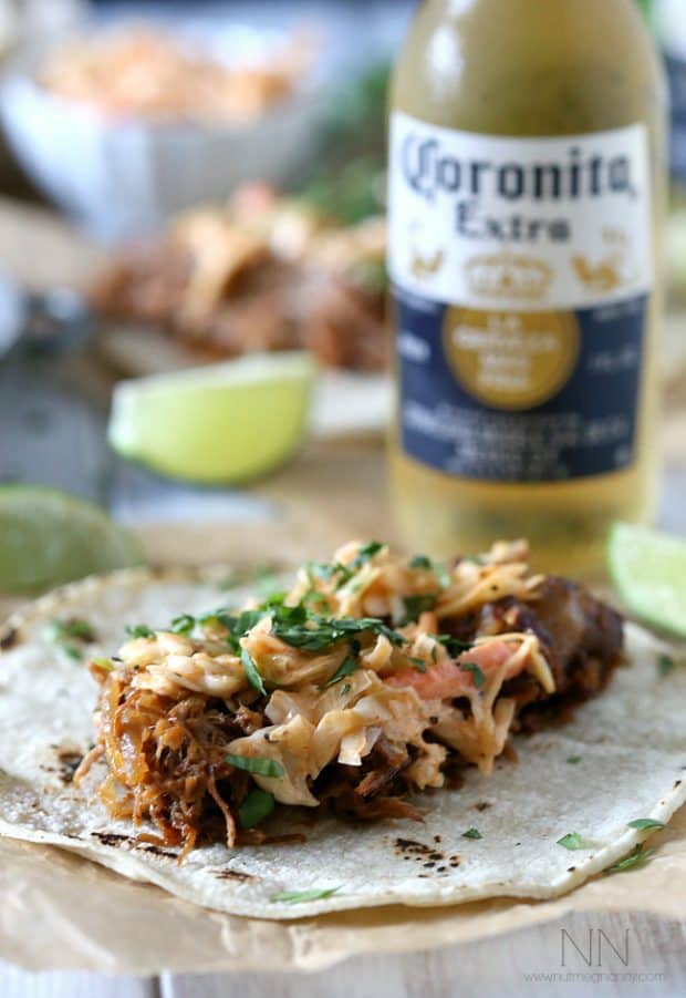 Ginger Beer Pulled Pork Tacos on a plate topped with slaw. 