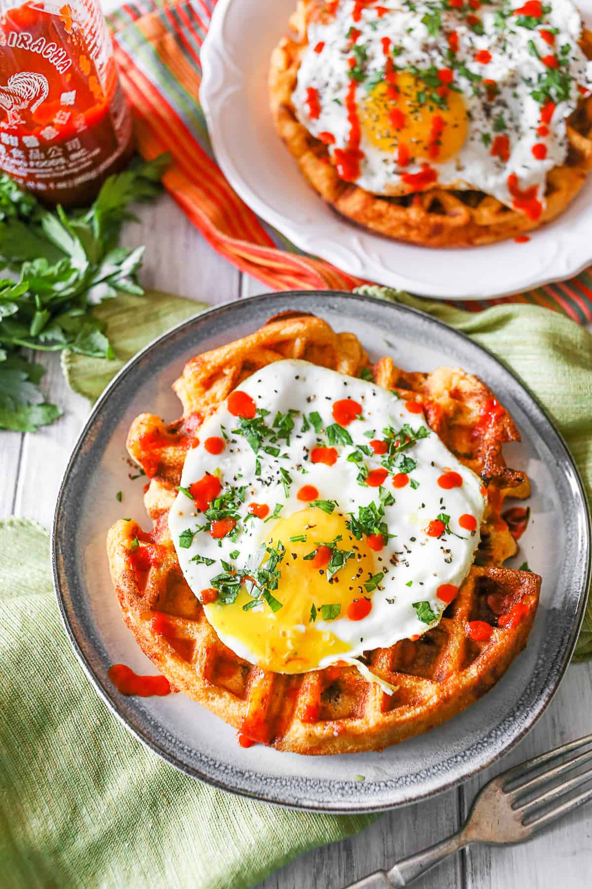 Cheddar Sausage Cornmeal Waffles drizzled with sriracha. 