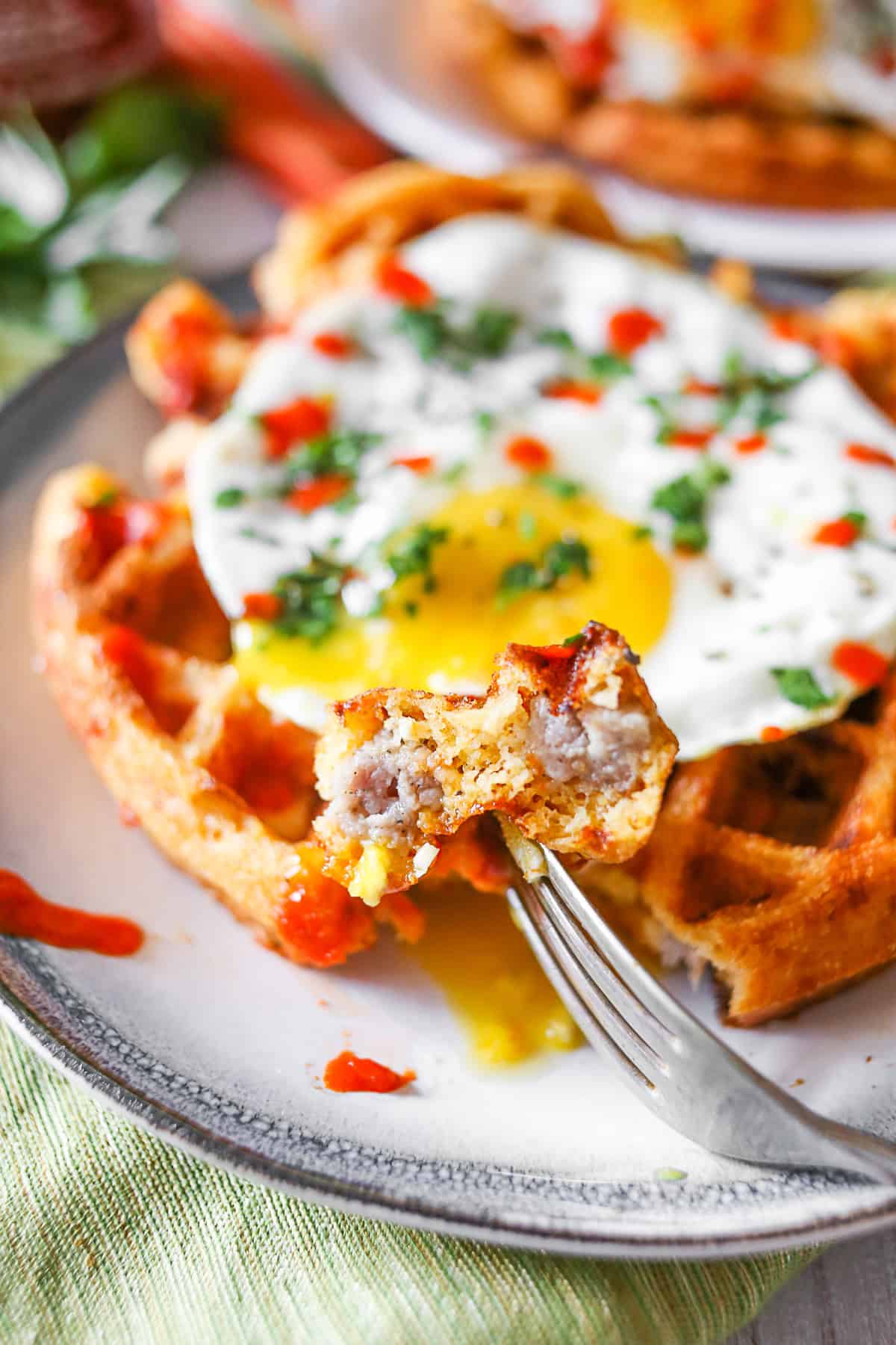 Cheddar Sausage Cornmeal Waffles cut and on a fork. 