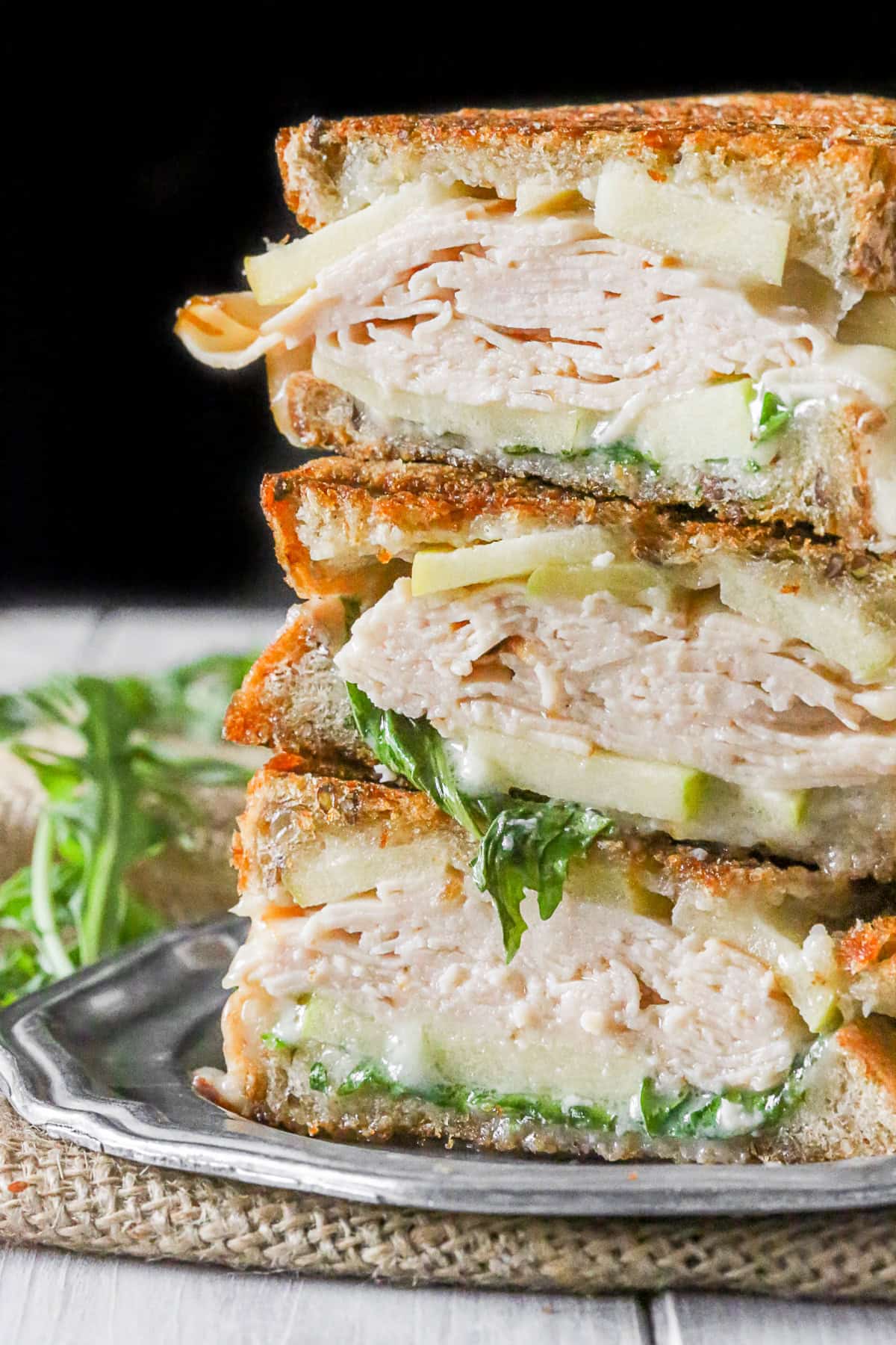 Turkey Apple Brie Panini cut and stacked on a plate.
