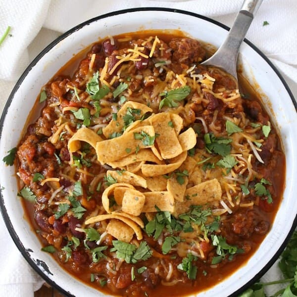 This slow cooker pumpkin chili is packed full of pumpkin puree, spicy Italian sausage and lots of beans and vegetables. This hearty soup is perfect for cold winter nights.