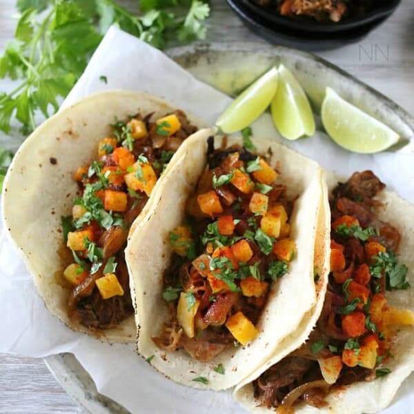 chipotle apple butter carnitas on a plate topped with toppings