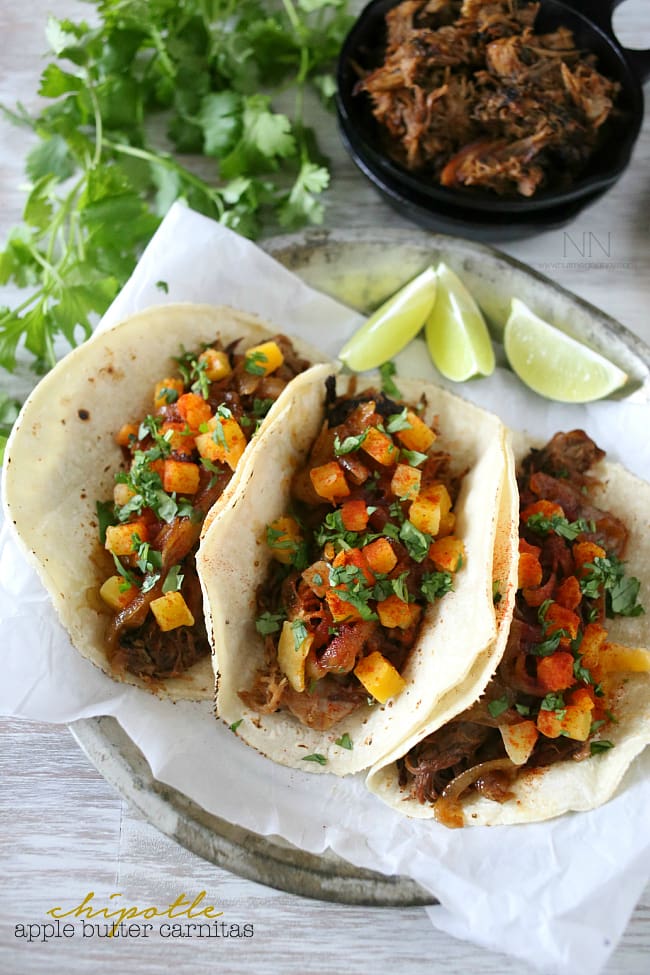 Plate of apple butter carnitas with lime wedges on the side.