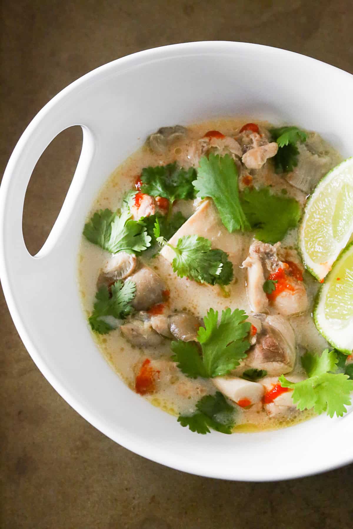 Tom Kha Gai in a white bowl. 
