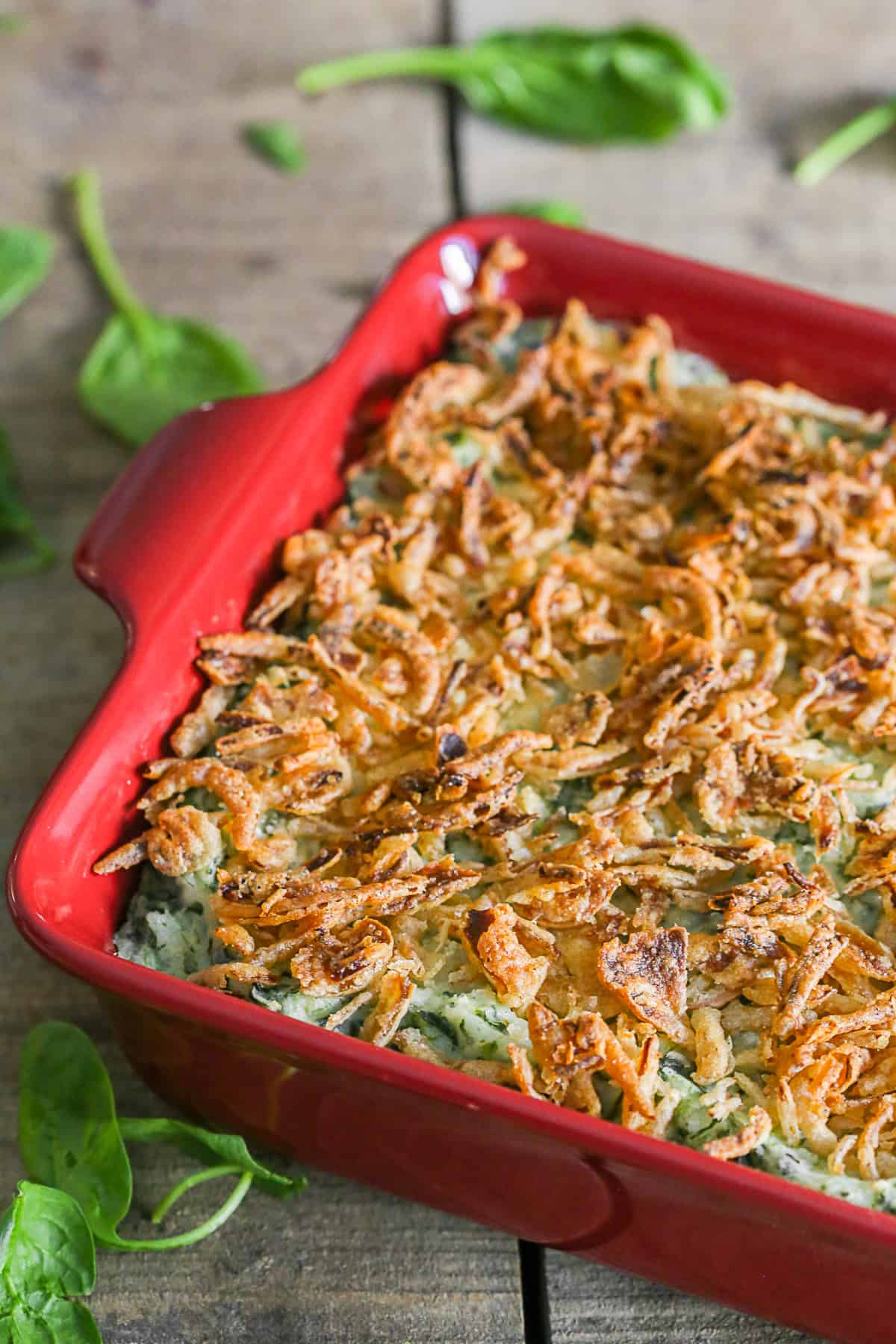 Spinach Parmesan Baked Mashed Potatoes cooked in a red ceramic dish. 