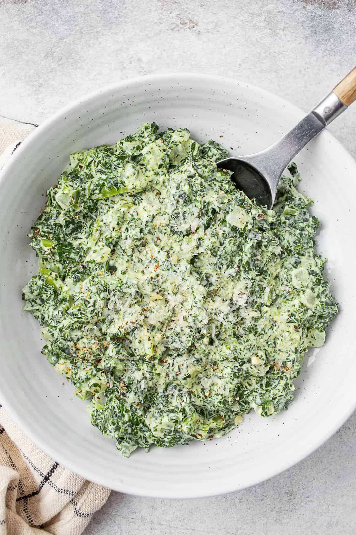 Creamed Kale in a white ceramic bowl. 