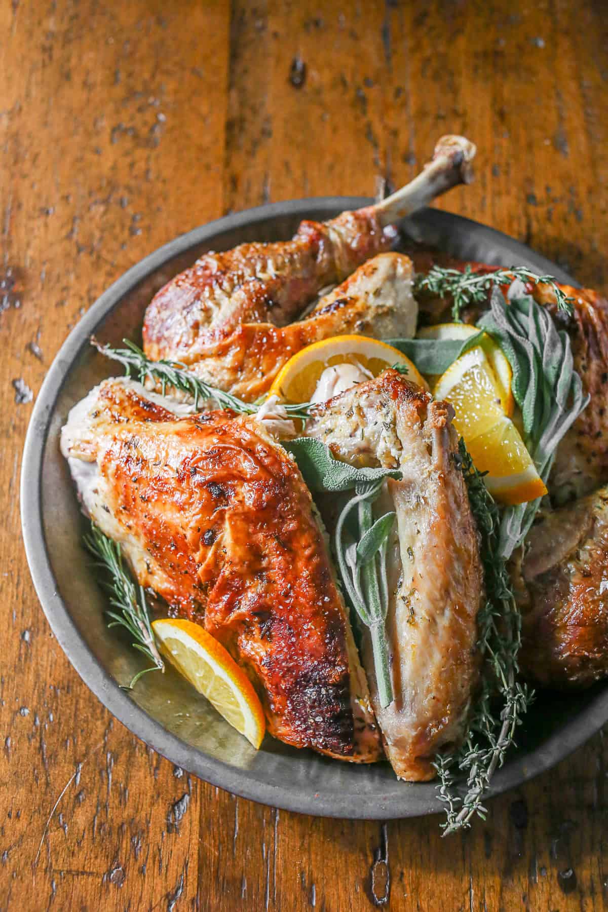 This herbed mayonnaise roast turkey is the perfect addition to your Thanksgiving table. Full of orange, sage, rosemary and thyme it's super moist and totally easy! Herbed Mayonnaise Roast Turkey sliced on a platter.