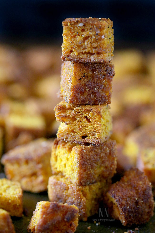 These simple pumpkin cornbread croutons are made from homemade pumpkin sage cornbread and are ready in just minutes! Perfect on soup, salad or in stuffing. Pumpkin Cornbread Croutons stacked on top of each other.