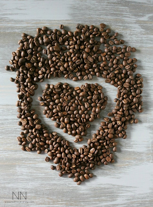 Coffee beans on a table in the shape of a heart. 