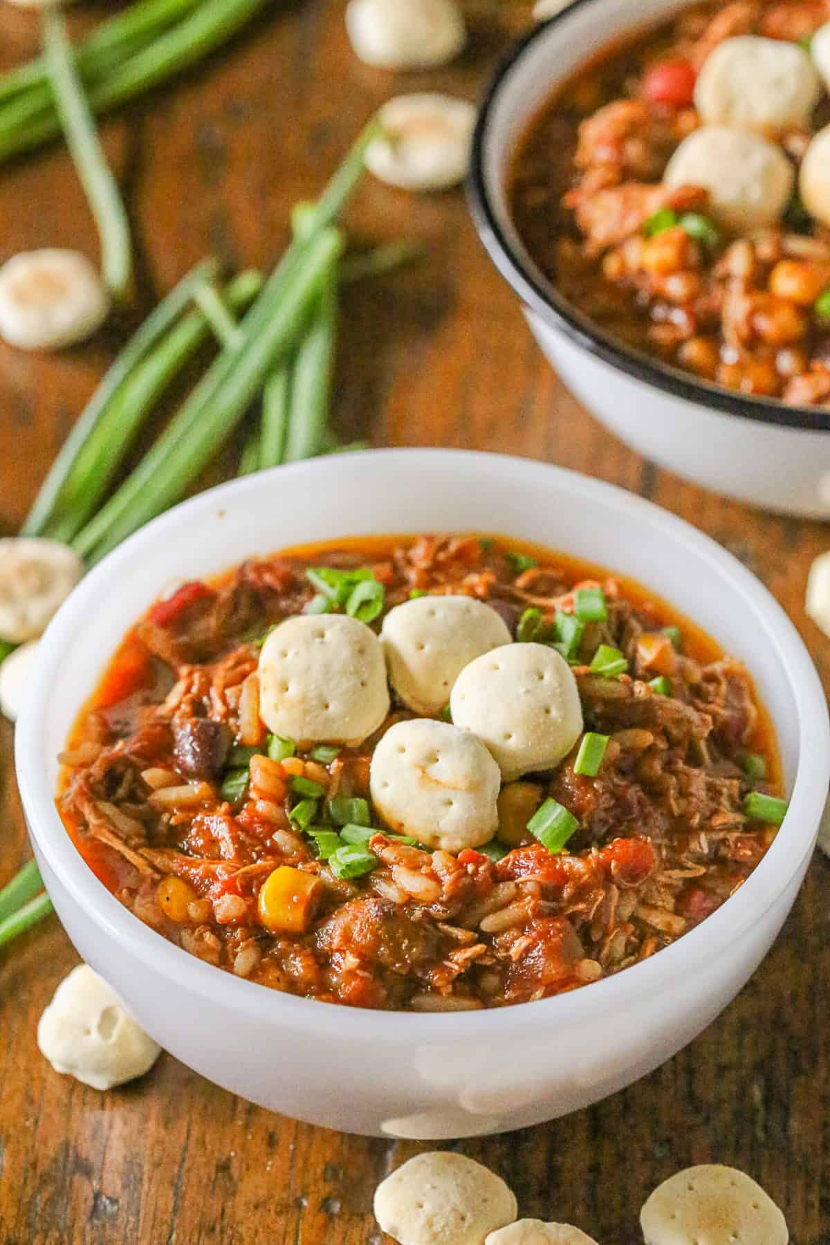 This simple turkey wild rice chili is the perfect way to use up all that leftover Thanksgiving turkey. Full of spicy flavor and perfect when topped with crackers. Turkey Wild Rice Chili on table with crackers.